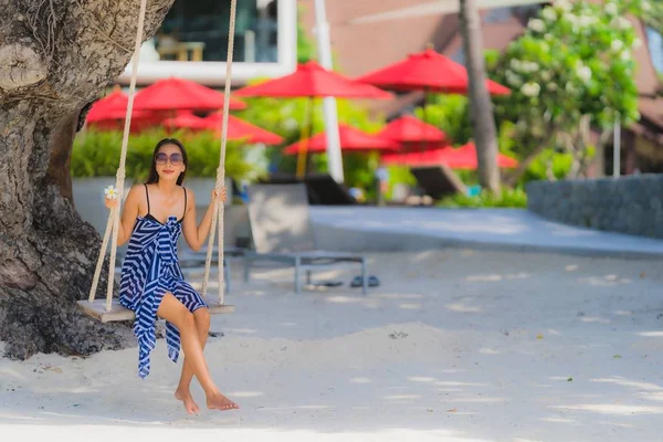 Portret jonge Aziatische vrouw zittend op Swing touw en zee rond — Stockfoto