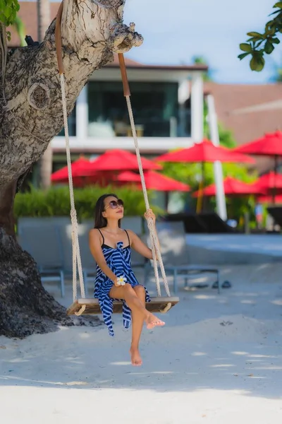 Portret jonge Aziatische vrouw zittend op Swing touw en zee rond — Stockfoto