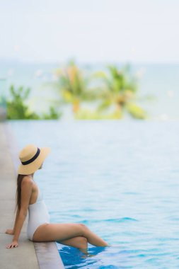 Portre genç asya kadın mutlu gülümseme yüzme kaka etrafında dinlenmek