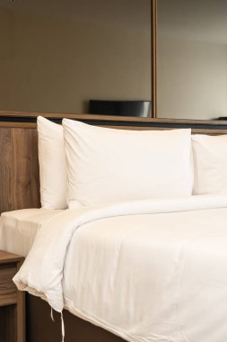 Yastık ve battaniye yatağın üzerinde, içinde lamba süslemesi var.