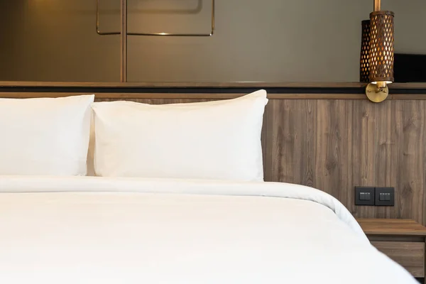 Подушка и одеяло на кровати со светлой лампой украшения интерьера — стоковое фото