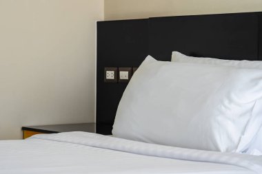 Yastık ve battaniye yatağın üzerinde, içinde lamba süslemesi var.