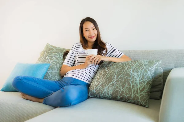 Portrait belle jeune femme asiatique sur canapé avec tasse de café — Photo