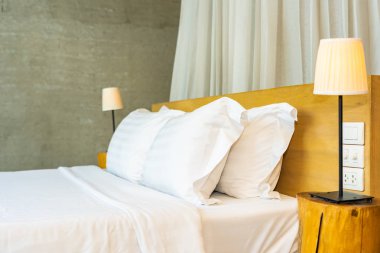 Yastık ve battaniye yatağın üzerinde, içinde lamba süslemesi var.