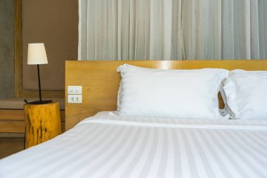 Yastık ve battaniye yatağın üzerinde, içinde lamba süslemesi var.