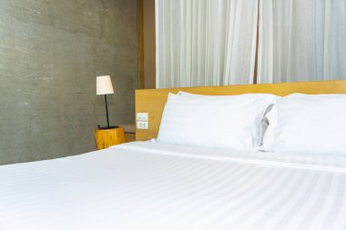 Yastık ve battaniye yatağın üzerinde, içinde lamba süslemesi var.