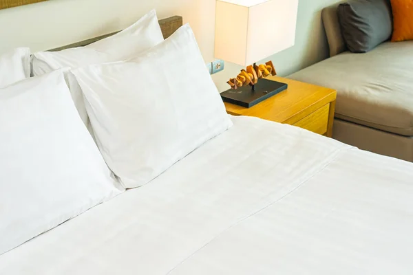 Vit bekväm kudde på sängen dekoration med ljus lampa — Stockfoto