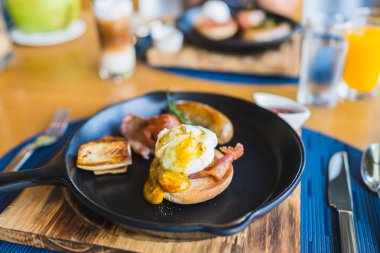 Sıcak tavada yumurtalı Benedict sosisi ile kahvaltı.