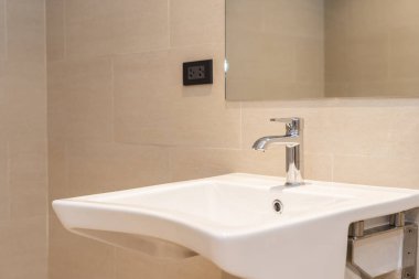 Banyoda musluk desenli beyaz lavabo.