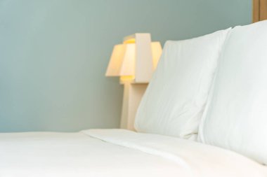 Yastık ve battaniye yatağın üzerinde, içinde lamba süslemesi var.