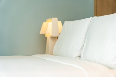 Yastık ve battaniye yatağın üzerinde, içinde lamba süslemesi var.