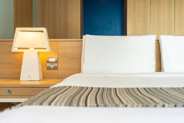 Yastık ve battaniye yatağın üzerinde, içinde lamba süslemesi var.