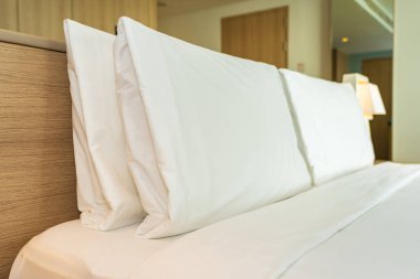 Yastık ve battaniye yatağın üzerinde, içinde lamba süslemesi var.