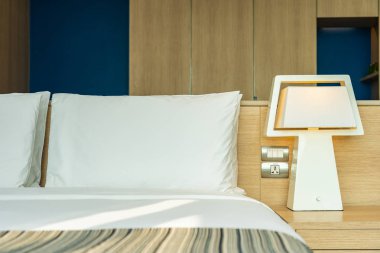 Yastık ve battaniye yatağın üzerinde, içinde lamba süslemesi var.