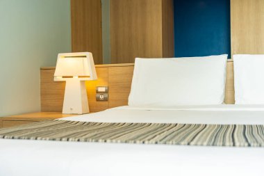 Yastık ve battaniye yatağın üzerinde, içinde lamba süslemesi var.