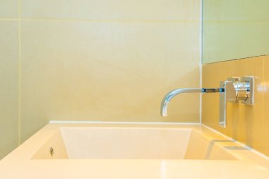 Banyoda musluk desenli beyaz lavabo.