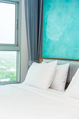 Yastık ve battaniye yatağın üzerinde, içinde lamba süslemesi var.