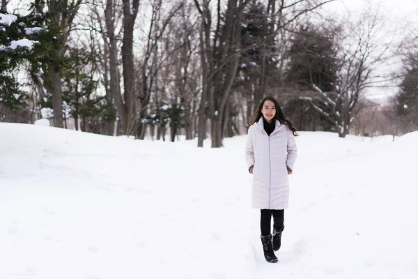 Hermosa joven asiática mujer sonriendo feliz para viajar en la nieve ganar — Foto de Stock