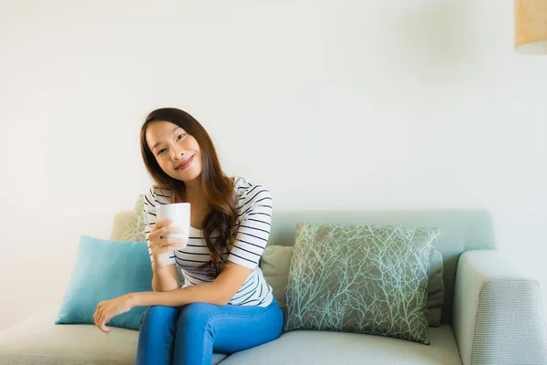 Portrait belle jeune femme asiatique sur canapé avec tasse de café — Photo