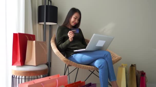 美しいアジアの女性が自宅でノートパソコンでEショッピングをする映像 — ストック動画