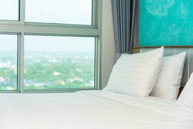 Yastık ve battaniye yatağın üzerinde, içinde lamba süslemesi var.