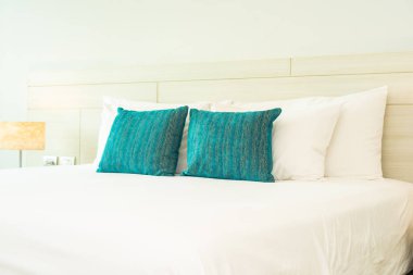 Yastık ve battaniye yatağın üzerinde, içinde lamba süslemesi var.