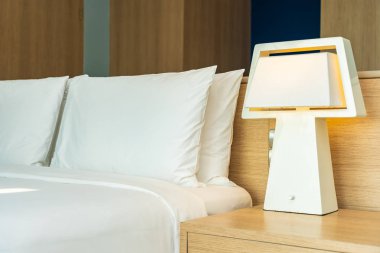 Yastık ve battaniye yatağın üzerinde, içinde lamba süslemesi var.