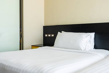 Yastık ve battaniye yatağın üzerinde, içinde lamba süslemesi var.