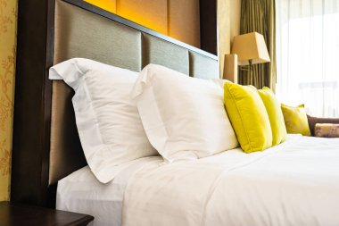 Yastık ve battaniye yatağın üzerinde, içinde lamba süslemesi var.