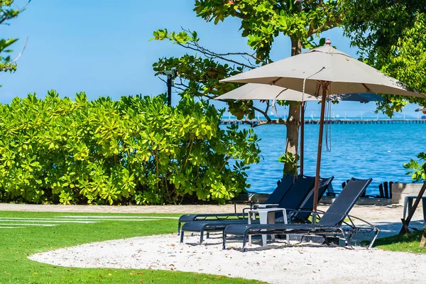 Ombrellone e sedia sulla spiaggia e sul mare con cielo azzurro — Foto Stock