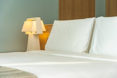 Yastık ve battaniye yatağın üzerinde, içinde lamba süslemesi var.