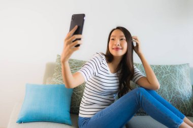 Güzel bir Asyalı kadın portresi. Cep telefonu kullanıyor ya da konuşuyor.