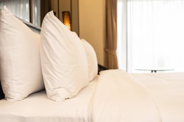 Yastık ve battaniye yatağın üzerinde, içinde lamba süslemesi var.