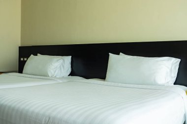 Yastık ve battaniye yatağın üzerinde, içinde lamba süslemesi var.