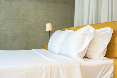 Yastık ve battaniye yatağın üzerinde, içinde lamba süslemesi var.