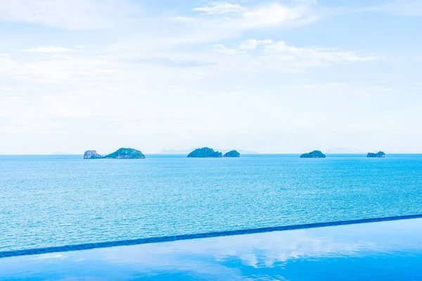 Beautiful outdoor swimming pool with sea ocean on white cloud bl — Stock Photo, Image