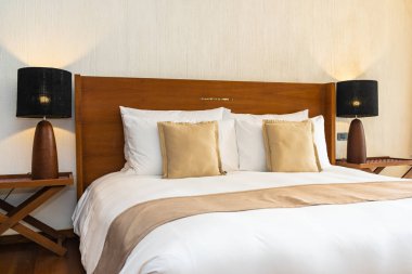 Yatak üzerinde güzel konforlu lüks beyaz yastık ve battaniye Dec