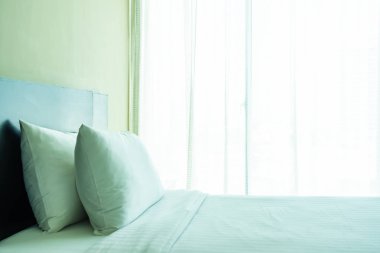 Yastık ve battaniye yatağın üzerinde, içinde lamba süslemesi var.