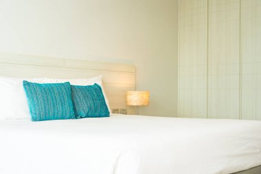 Yastık ve battaniye yatağın üzerinde, içinde lamba süslemesi var.