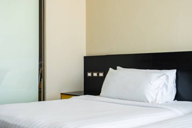 Yastık ve battaniye yatağın üzerinde, içinde lamba süslemesi var.