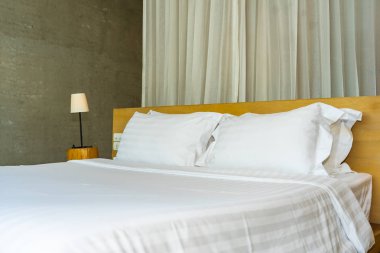 Yastık ve battaniye yatağın üzerinde, içinde lamba süslemesi var.