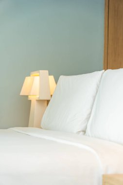 Yastık ve battaniye yatağın üzerinde, içinde lamba süslemesi var.