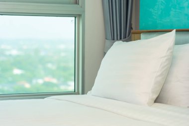 Yastık ve battaniye yatağın üzerinde, içinde lamba süslemesi var.