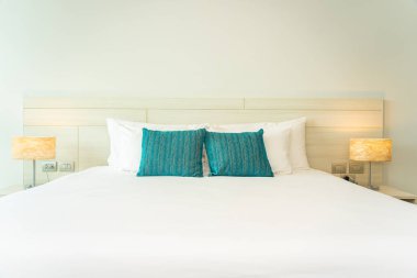 Yastık ve battaniye yatağın üzerinde, içinde lamba süslemesi var.