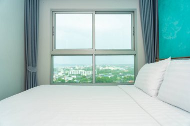 Yastık ve battaniye yatağın üzerinde, içinde lamba süslemesi var.