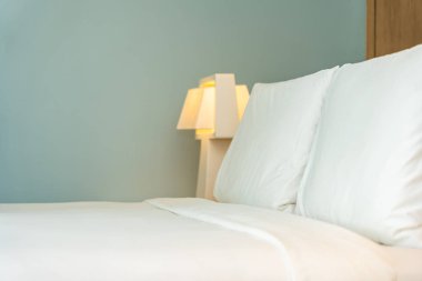 Yastık ve battaniye yatağın üzerinde, içinde lamba süslemesi var.