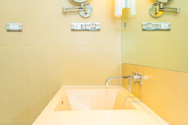Banyoda musluk desenli beyaz lavabo.