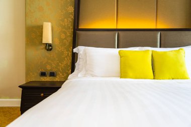 Yastık ve battaniye yatağın üzerinde, içinde lamba süslemesi var.