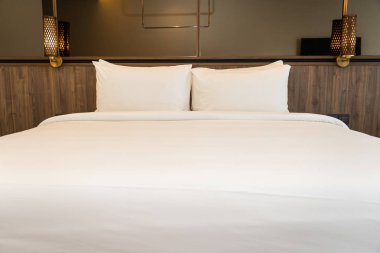 Yastık ve battaniye yatağın üzerinde, içinde lamba süslemesi var.