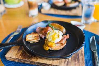 Sıcak tavada yumurtalı Benedict sosisi ile kahvaltı.